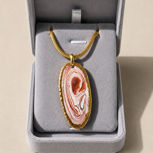 Necklace with a pink stone pendant in a gray jewelry box on a beige background
