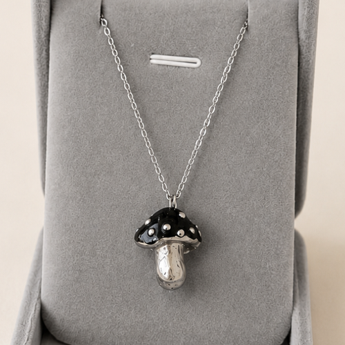 Silver necklace with a pendant in a gray jewelry box on a beige background