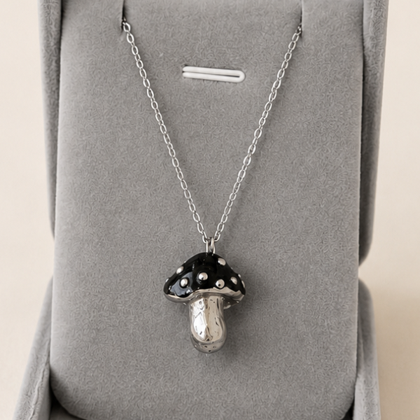 Silver necklace with a pendant in a gray jewelry box on a beige background