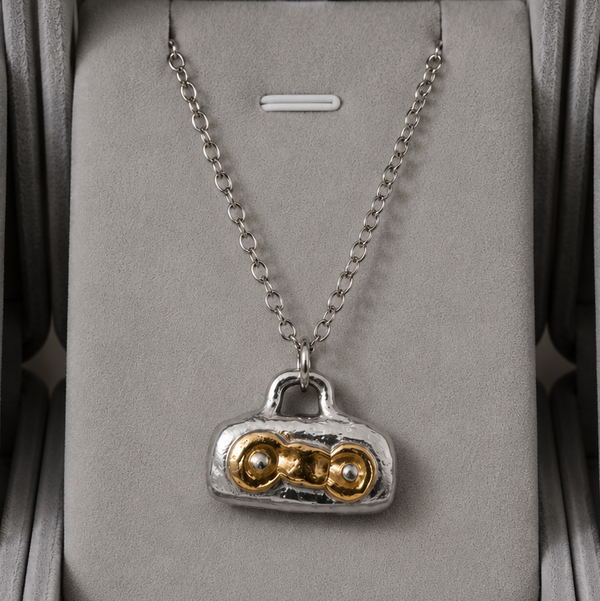 Necklace with a unique pendant in a gray jewelry box