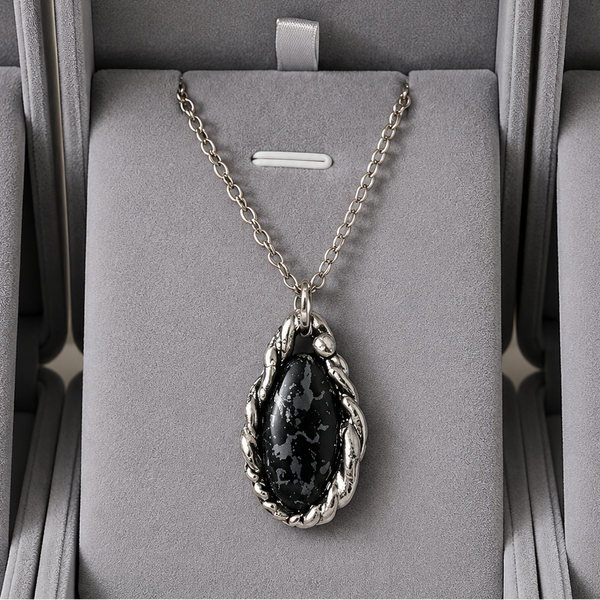 Necklace with a dark pendant in a gray jewelry box