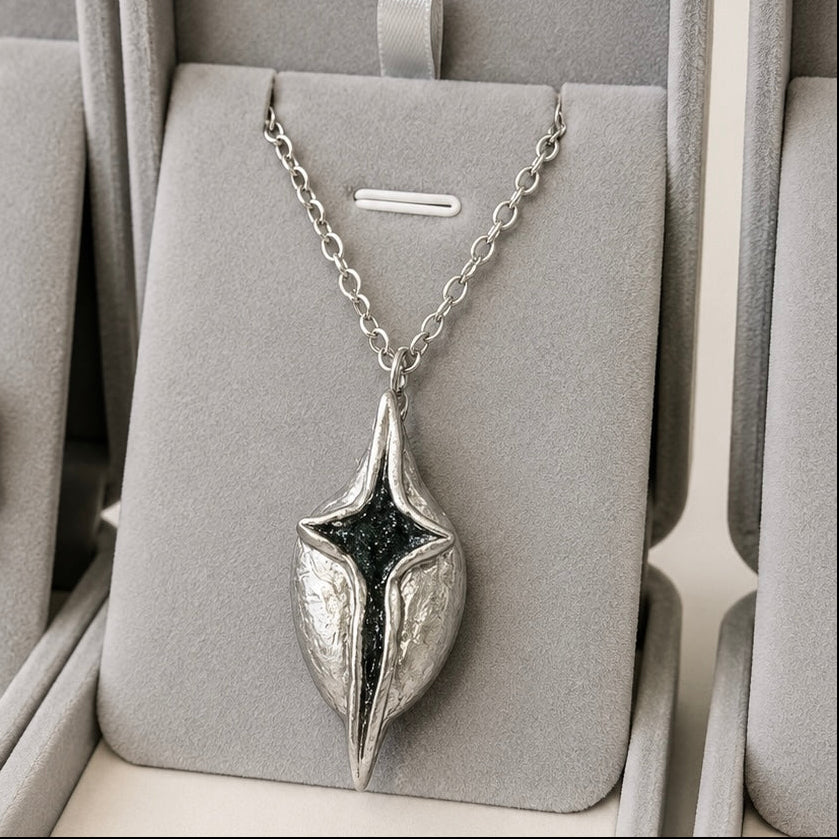Silver necklace with a unique pendant in a gray jewelry box