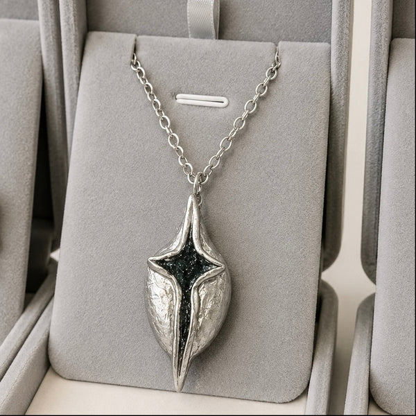 Silver necklace with a unique pendant in a gray jewelry box